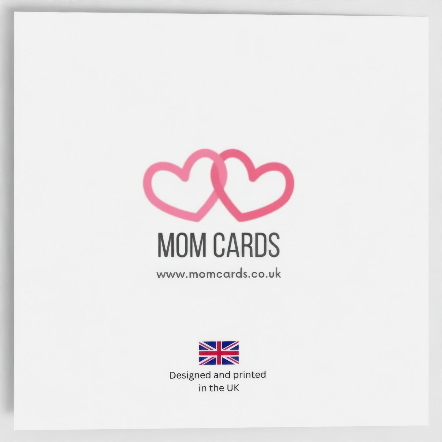 Outside back of the card. Includes Mom Cards logo (two entwined pink hearts), web address and "Designed and printed in the UK" text with Union Jack image.
