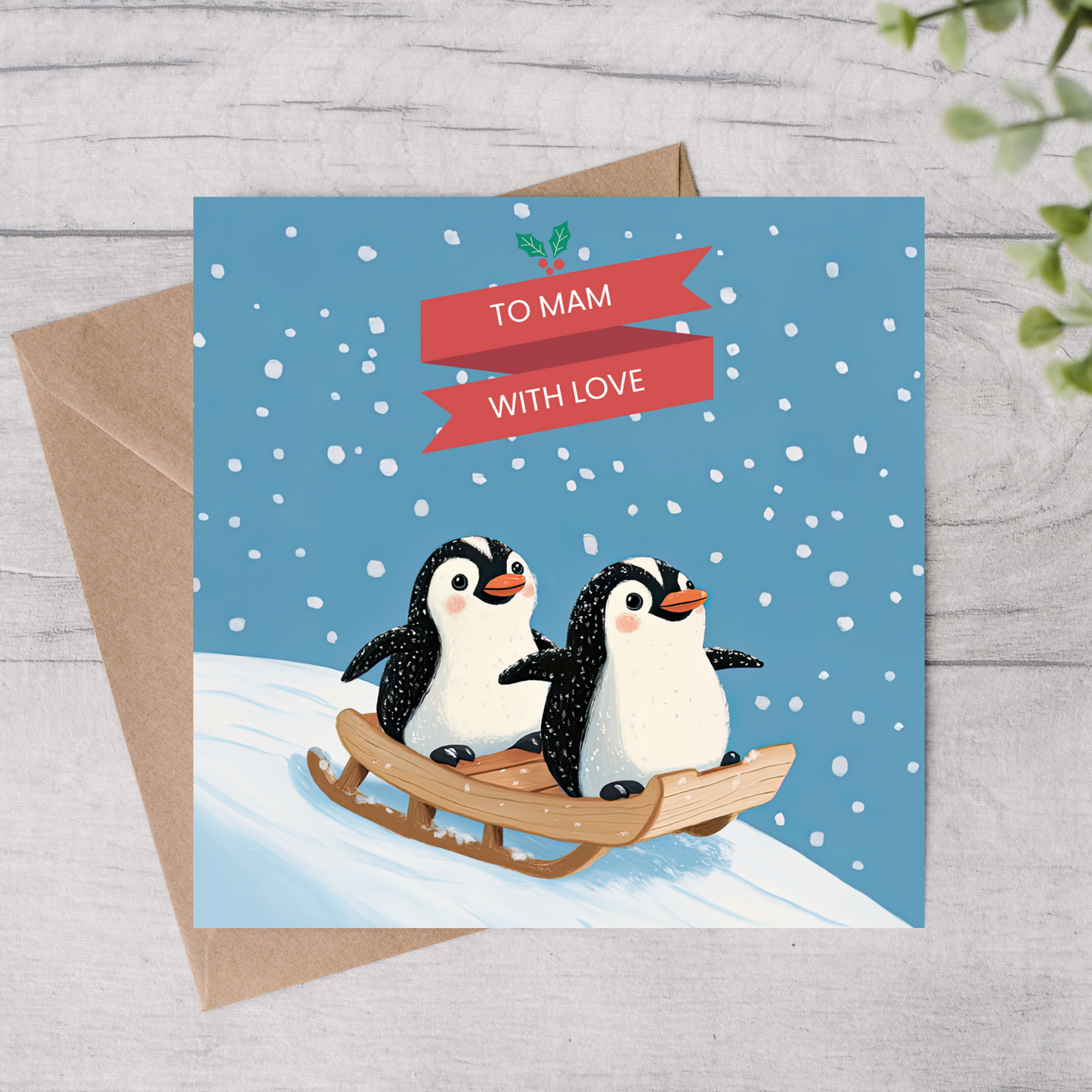 The design: two penguins sledging in the snow. Text reads: "To Mam with love".