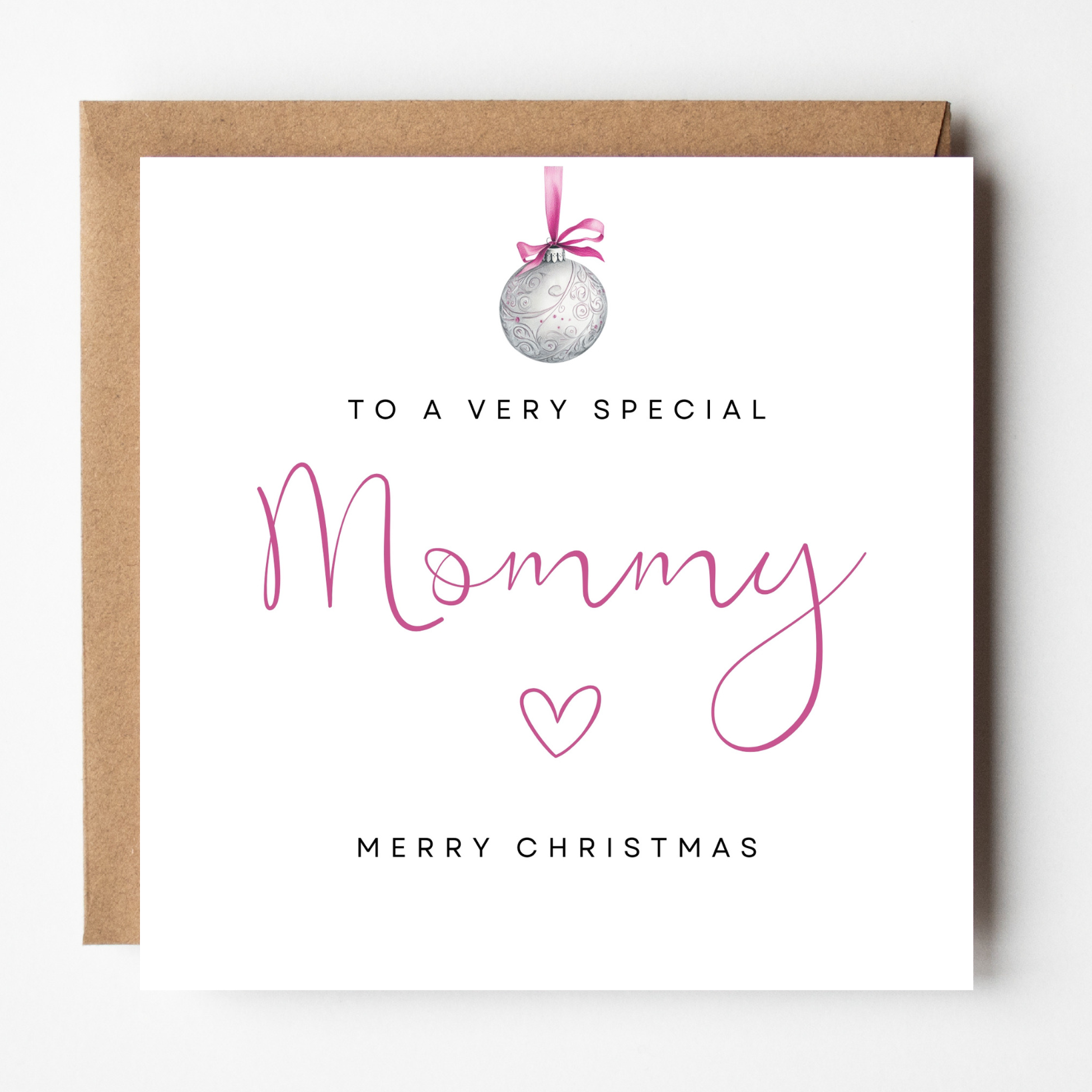 A mockup of the Mommy Pink Bauble Christmas card, shown with brown Kraft envelope.